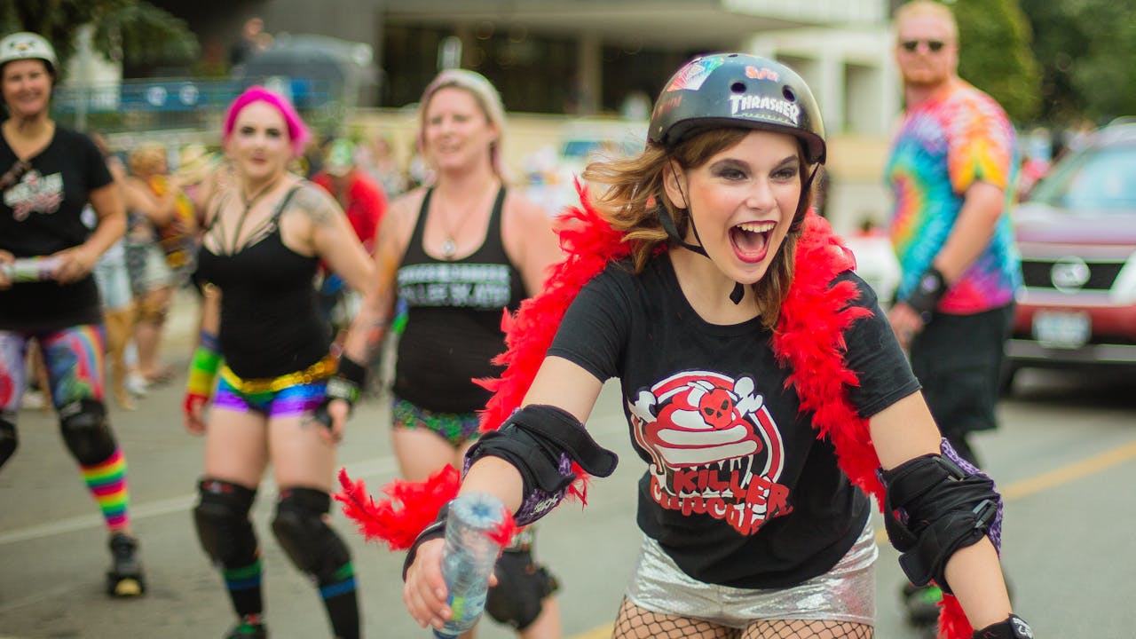 Energetic roller derby enthusiasts participating in a lively street parade in London, Ontario.